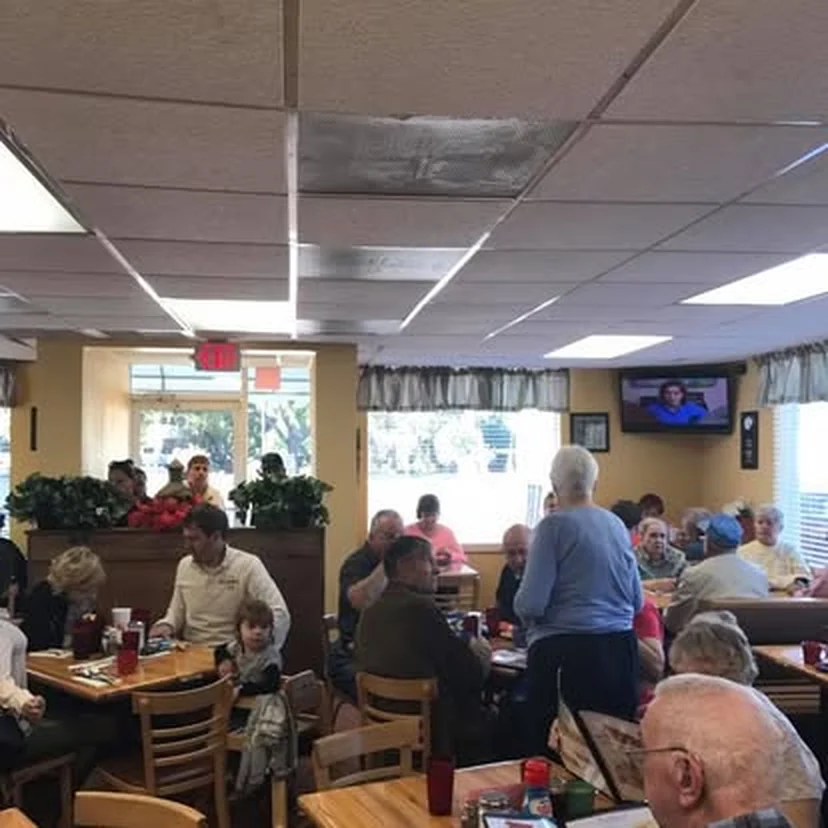 Familias y clientes en el comedor de Kountry Kitchen junto a las ventanas