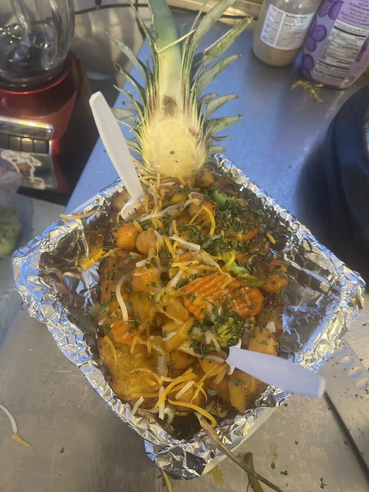 Stir fry con vegetales y queso servido dentro de una piña ahuecada, con la corona puesta
