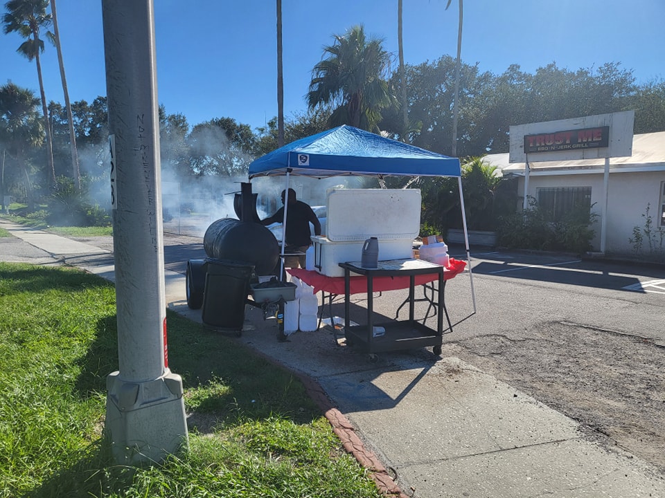 Outdoor smoker setup at storefront