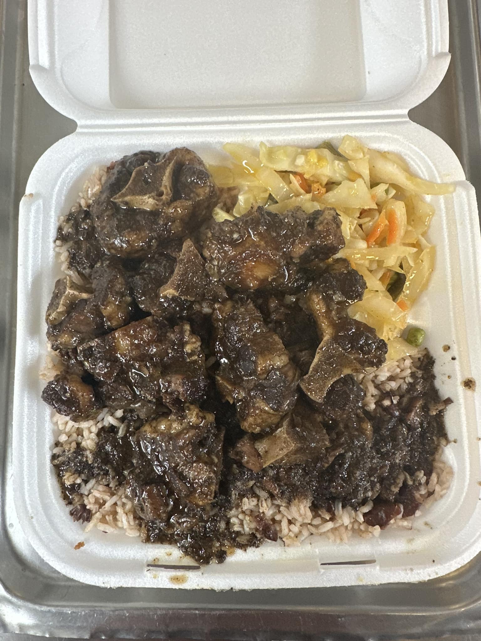 Oxtails over rice and peas with cabbage