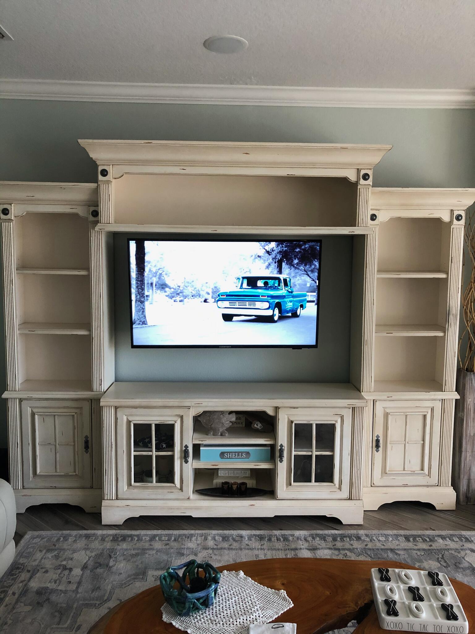 Finished TV mounted above entertainment console