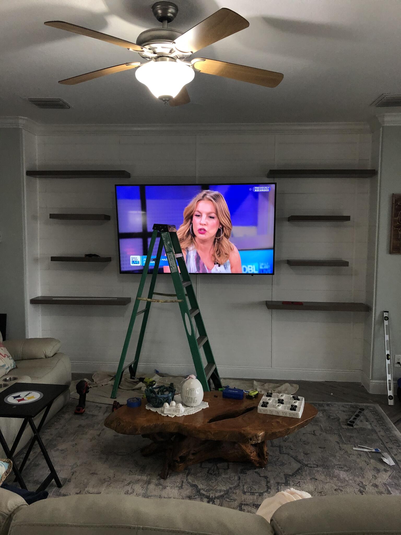 TV mount in progress with tools, ladder, drill